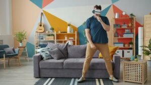 Person mit VR-Headset und Controller im modern eingerichteten Wohnzimmer