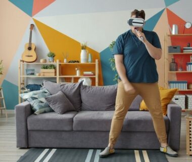 Person mit VR-Headset und Controller im modern eingerichteten Wohnzimmer